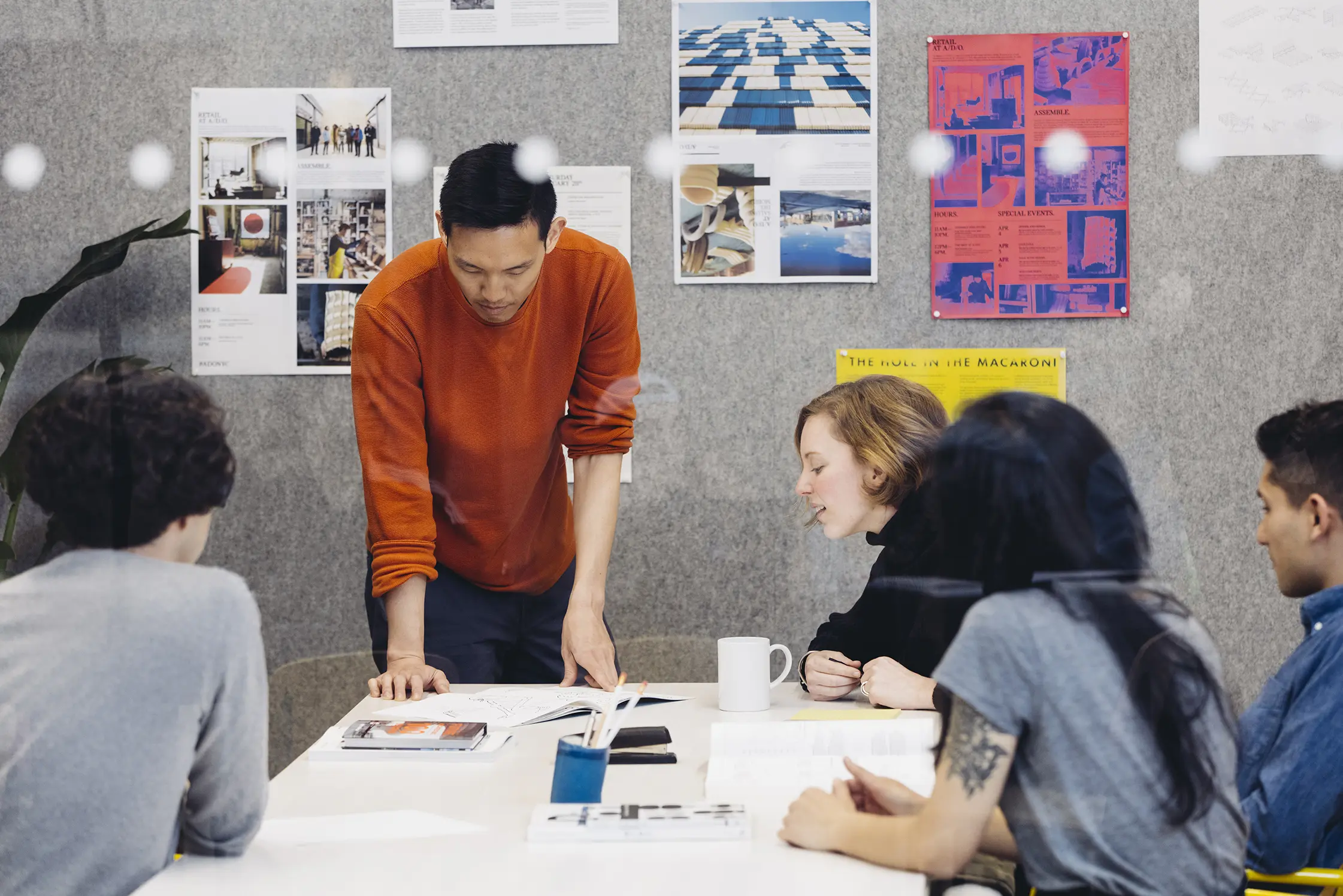Studio working session around a pinboard wall
